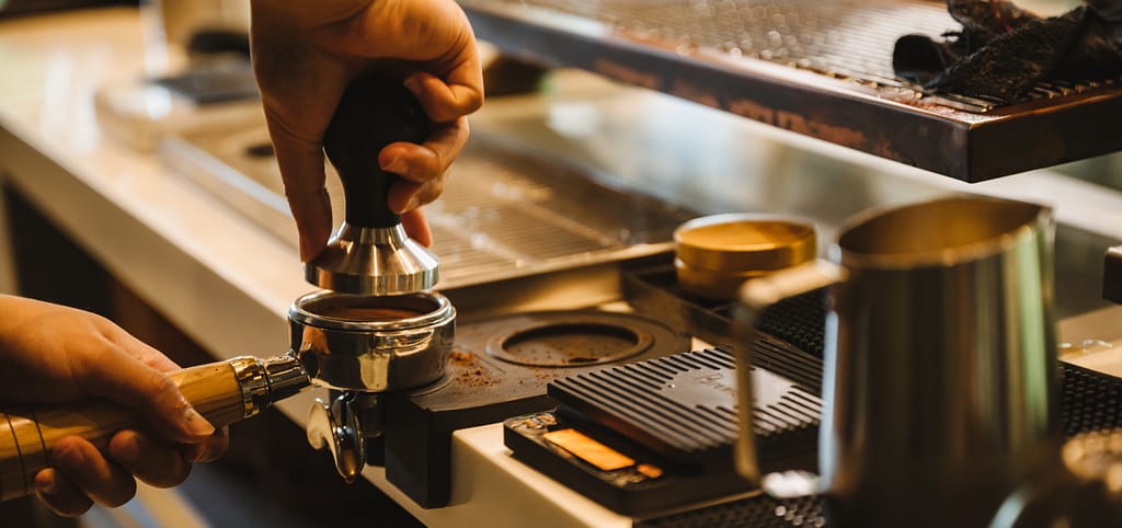 Mit Hilfe eines Tampers wird der Espresso festgedrückt.